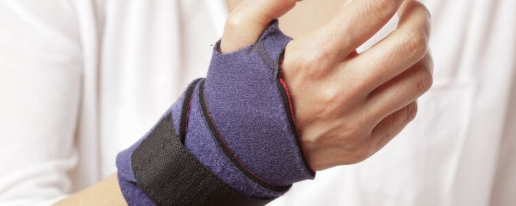 Individual wearing a wrist brace for support and pain relief.
