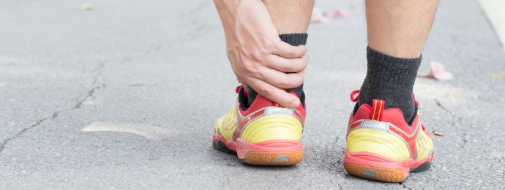 Runner holding ankle injury on a run
